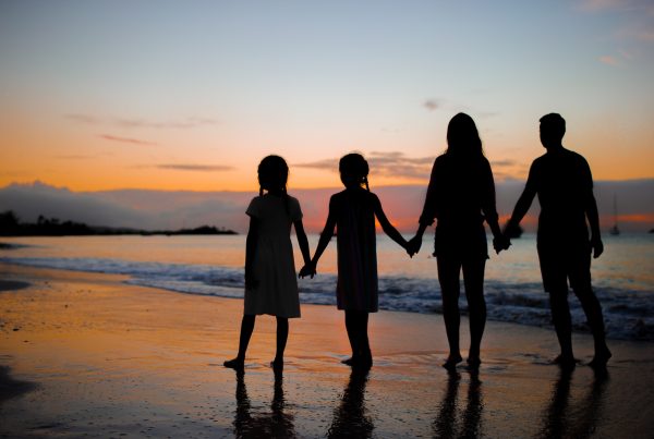 Family silhouette in the sunset on beach vacation
