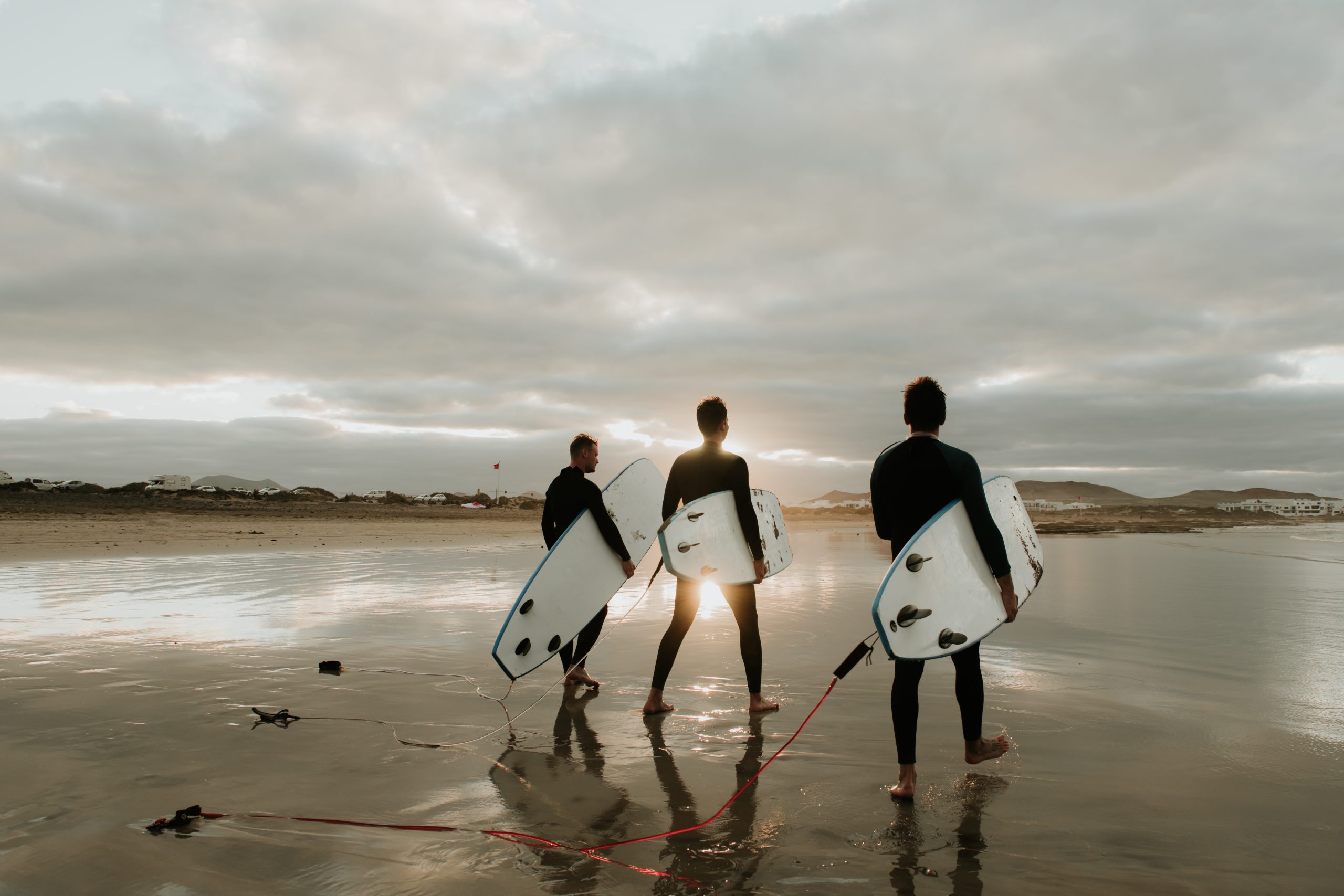 People with surfboard walking near sea