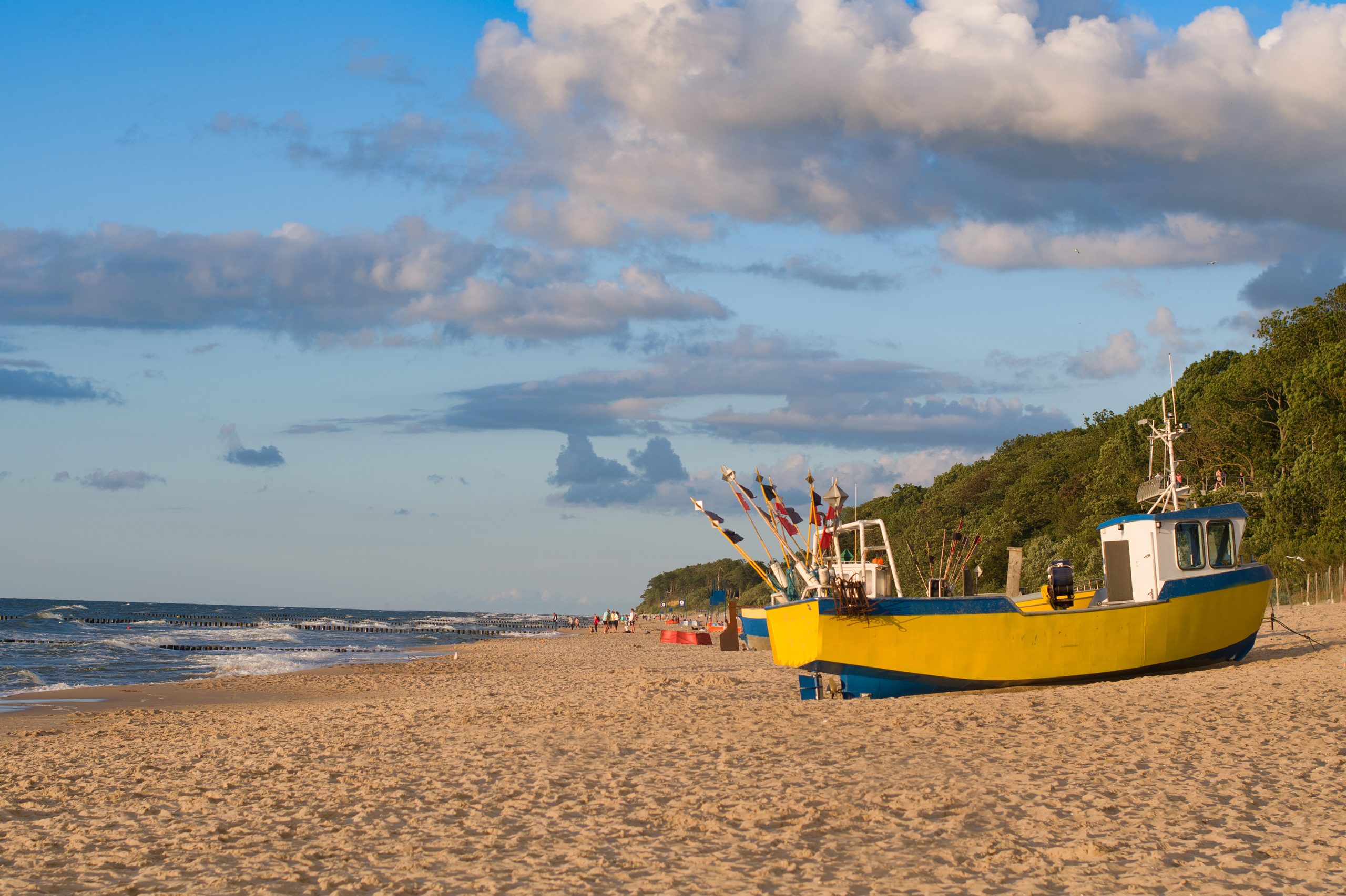 yellow fishing boat on a sandy beach
