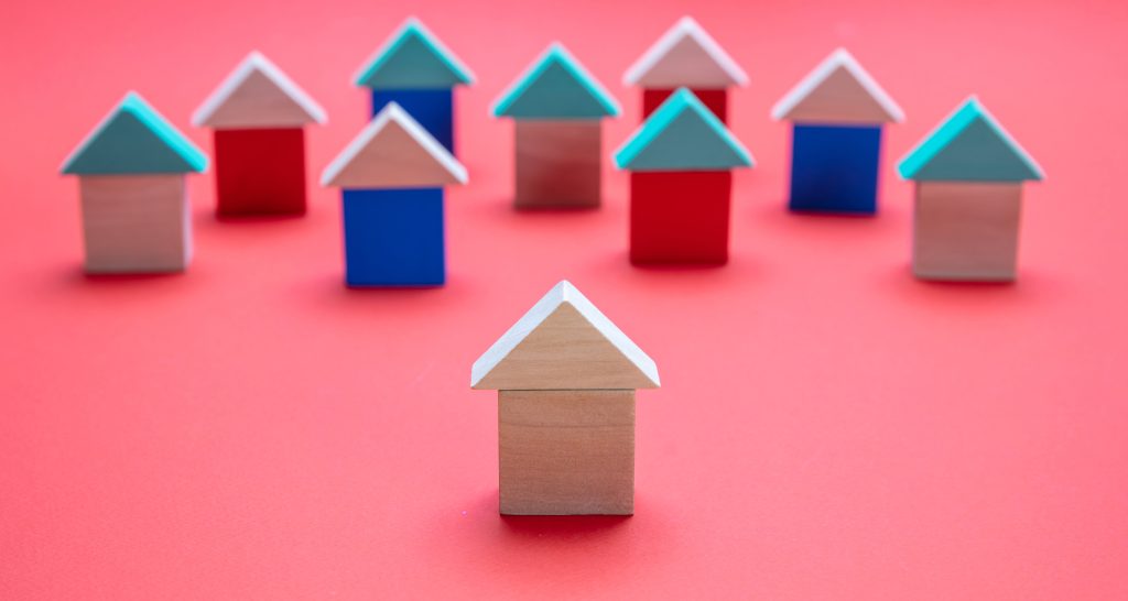 Real estate and standing out concept, One house model ahead of the others, red color background